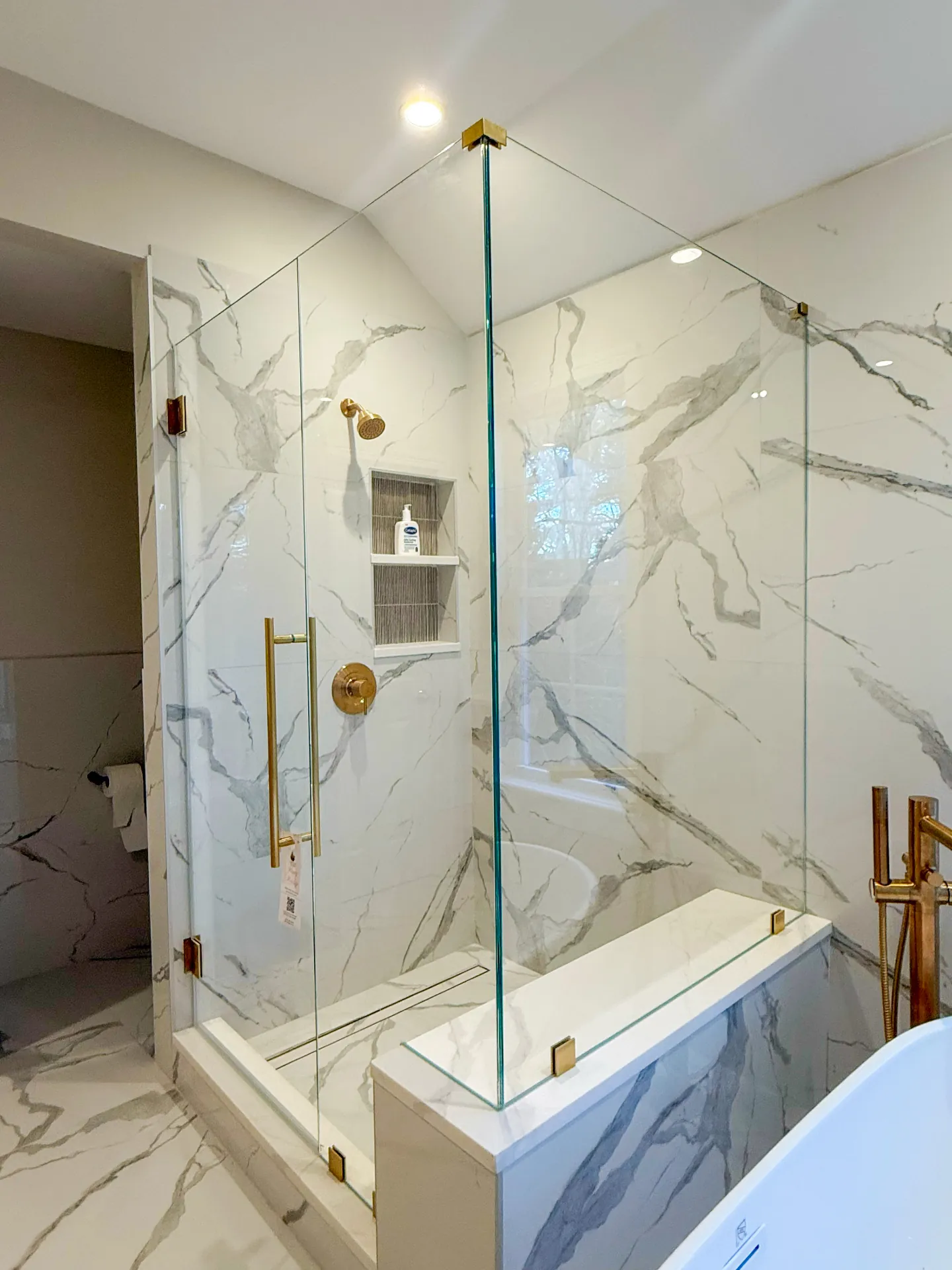 Custom glass shower installation in a marble bathroom